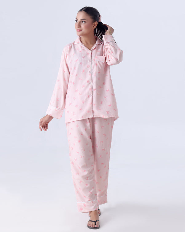 Woman wearing a pink pajama set on a white background